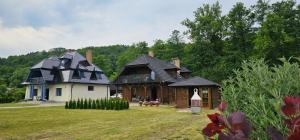 a large house and a home on a field at Domek Przy Rzece in Kazimierz Dolny