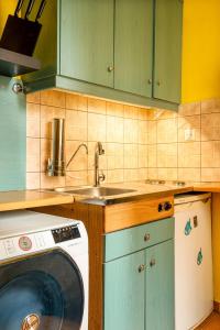 a kitchen with a sink and a washing machine at oscar city room in Athens