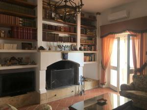 a living room with a fireplace and a tv at Villa Francesca - Camere con giardino in Castellaneta