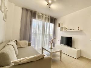 uma sala de estar com um sofá e uma televisão em Apartamento con piscina Sant Carles de la Ràpita em Sant Carles de la Ràpita