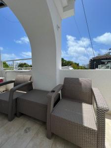 a balcony with two chairs and a table and a window at Hostal islamar in San Andrés