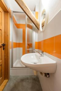 a bathroom with a white sink and a shower at Penzion pod Pralesem in Velké Karlovice