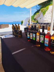 una mesa con un montón de botellas de alcohol en ella en Estate Franca Wine and Olive oil en Koper