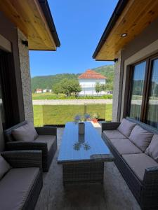 a patio with couches and a table and a view at VILA VIKTORIJA in Kolašin