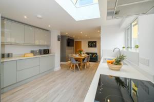 a kitchen with white cabinets and a dining room at Primrose Cottage, Leiston, near Sizewell, Thorpeness and Aldeburgh - Managed by Aldeburgh Coastal Cottages in Leiston