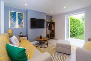 a living room with a couch and a tv at Primrose Cottage in Leiston