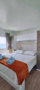 ein Schlafzimmer mit 2 Betten und Handtüchern darauf in der Unterkunft Mobile home Greta in Klenovica