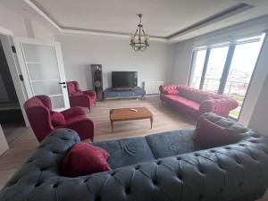 a living room with a couch and chairs and a tv at Reis apart in Trabzon