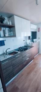a kitchen with wooden cabinets and a stove top oven at Mobile home Greta in Klenovica