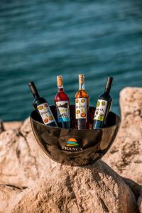 un tazón lleno de botellas de cerveza sentadas en una roca en Estate Franca Wine and Olive oil en Koper