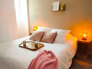 een bed met een dienblad met twee glazen erop bij Appartement avec terrasse proche Nice et Monaco in Contes
