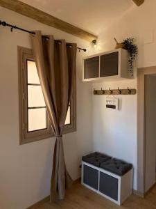 um quarto com uma janela, um banco e uma cortina em Le petit loft des halles em Béziers