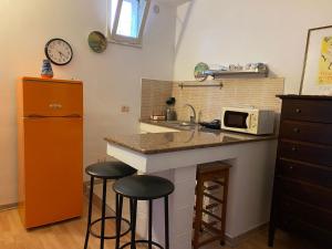 a kitchen with a counter with stools and a microwave at Casa Vacanze lecce Luppiu in Lecce