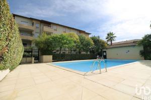 a swimming pool in front of a building at *Le Carpe Diem, Appartement 2 chambres, piscine, 2 Parking, Clim* in Montpellier