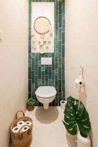 een badkamer met een toilet en een groene betegelde muur bij Le bohème du Panier in Marseille