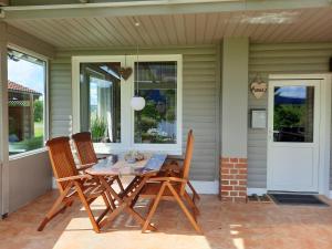 - une table et des chaises sur la terrasse couverte d'une maison dans l'établissement Ferienhaus am Weserberglandsee, à Lauenförde