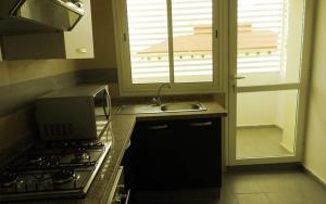 una cucina con piano cottura, lavandino e finestra di Séjour avec piscine proche de la mer a Tamaris