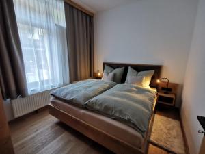 A bed or beds in a room at Das Wipferl - Dein Nest in den Bergen
