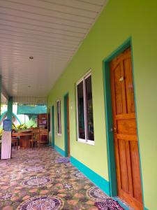a room with green walls and a wooden door at BARRIL GREEN HOMESTAY in Batuan