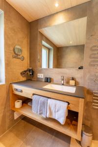 ein Bad mit einem Waschbecken und einem Spiegel in der Unterkunft Hotel Garni Krumbach in Damüls