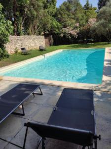una piscina con una mesa y un banco al lado en Le mas Rocamour, en Roquemaure