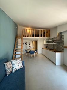 a living room with a blue couch and a kitchen at Casas da Corujeira in Porto