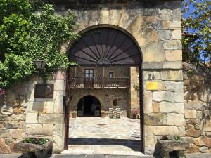 uma entrada para um edifício de pedra com um arco em Posada La Torre de La Quintana em Liendo