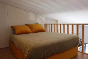 ein Bett mit zwei orangenen Kissen in einem Zimmer in der Unterkunft Casas da Corujeira in Porto