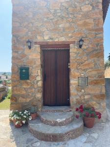 een stenen gebouw met een houten deur en bloemen bij Casa de Lilith in Aren