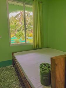 a bed in a room with a window at BARRIL GREEN HOMESTAY in Batuan