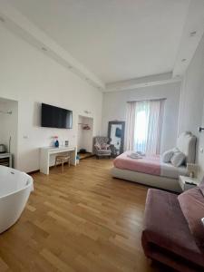 Habitación blanca grande con cama y TV. en Caracciolo Napoli BeB, en Nápoles