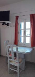 a kitchen with a table and two chairs and a window at Filina's Studio in Analipsi