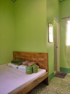 ein Schlafzimmer mit einem Bett mit grünen Wänden in der Unterkunft BARRIL GREEN HOMESTAY in Batuan