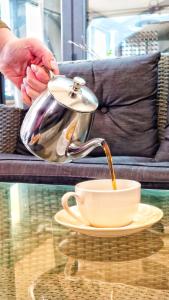 una cafetera vertiendo café en una taza sobre una mesa en The Watergate Inn, en York