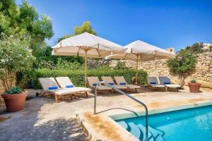 una piscina con sombrillas y sillas y una piscina en Casa Mezzodì' - Luxurious 18th C. Farmhouse with Gardens & Pool, en Kerċem