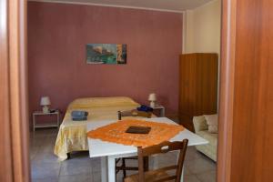 1 dormitorio con cama, mesa, mesa y sillas en Villa dei Bruno, en San Donato di Lecce