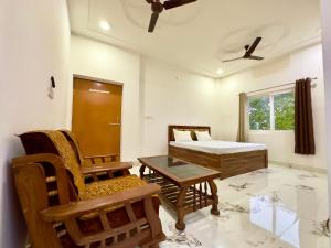 una habitación con una cama, una silla y una mesa en RAMALAYAM, en Ayodhya
