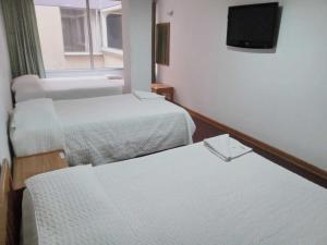 a hotel room with two beds and a television at HOTEL SUAREL CENTER in Duitama