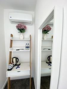 a walk in pantry with white shelves and flowers at Wembar Hotel in London