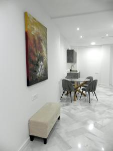 sala de estar con mesa, sillas y una pintura en Catalina Suites Apartments Downtown Valencia, en Valencia