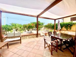 patio con tavolo, sedie e ombrellone di Casa Perla Marina sul mare a Castellammare del Golfo