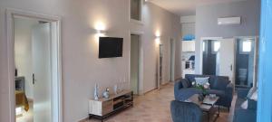 a living room with a blue couch and a tv at FILINA's luxury house in Maltezana