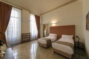 Posteľ alebo postele v izbe v ubytovaní Palazzo Sertorio Suites
