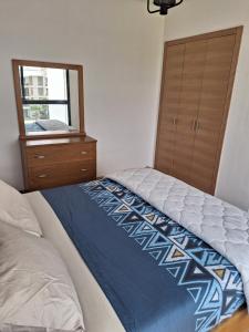 1 dormitorio con cama, tocador y espejo en Apartment place italie, en Rabat