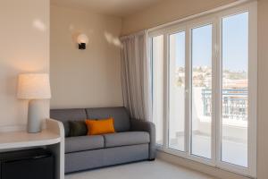 sala de estar con sofá y ventana grande en Yelo Promenade powered by Sonder en Niza