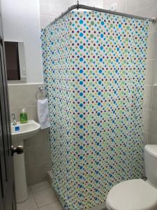 uma casa de banho com uma cortina de chuveiro e um WC. em Turquesa 2 