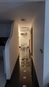 einen Flur, der zu einer Küche mit einem Kühlschrank führt in der Unterkunft Centar in Krapina
