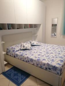 um quarto com uma cama com um edredão azul e branco em Il Faro d'Ogliastra em Bari Sardo