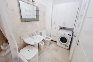 a white bathroom with a sink and a washing machine at Valentino Apartments, Newton Residence in Iaşi