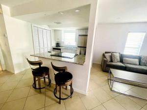 een keuken en een woonkamer met een aanrecht en stoelen bij Modern Sun N’ Lake Villa - Self Check-In in Sebring